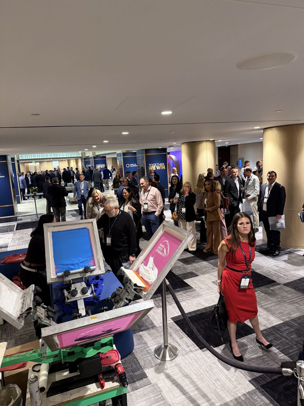 An elevated view of a live screen-printing activation drawing a crowd at a New York corporate event