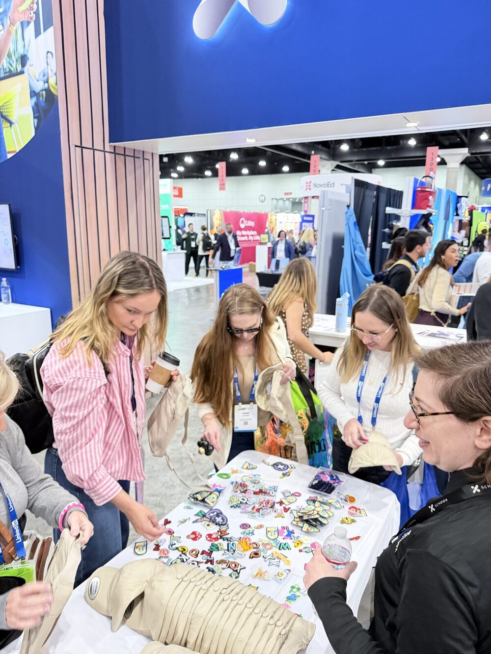 Guests browsing colorful embroidered patches laid out on a table at a trade-show activation