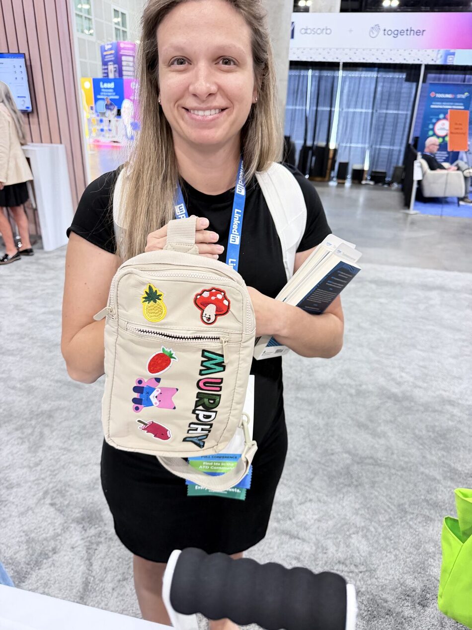 A guest holding a tan crossbody bag personalized with custom patches at a brand activation